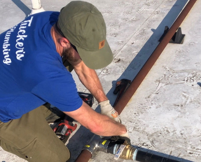 Micky from Tucker's Plumbing working on black iron gas pipe